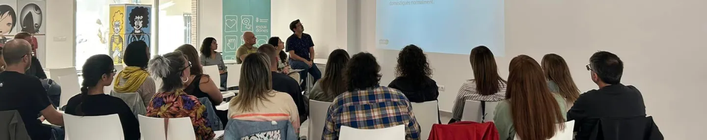 Grup de persones en una conferència observant el presentador