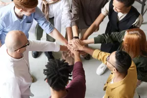 Grup de persones amb mans unides.